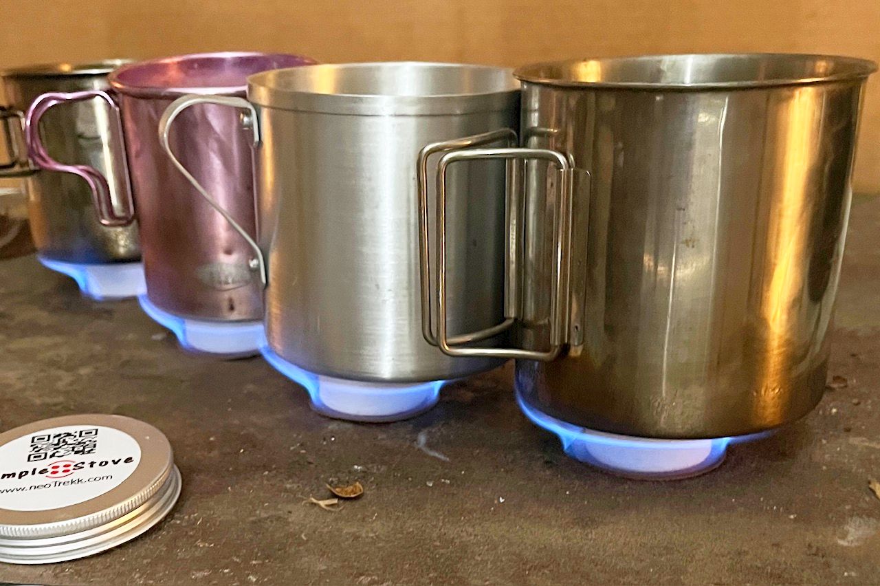 Four steel and copper mugs heating at once over the blue flames of SnowStones