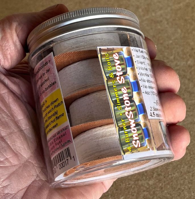 The SnowStoneStove jar held in a hand, with the Stones stacked inside